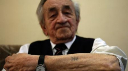 Były więzień KL Auschwitz Józef Stós prezentuje swój obozowy numer 752. Fot. PAP/A. Grygiel