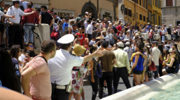 Policjanci zwracają turystom siedzącym na fantannie di Trevi w Rzymie. Fot. PAP/EPA