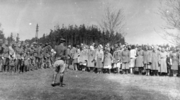 Żołnierze Brygady Świętokrzyskiej NSZ (po lewej) i grupa uwolnionych więźniarek (po prawej) z wyzwolonego obozu w Holýšovie. 05.05.1945. Fot. AIPN 