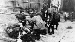 Udzielanie pomocy rannemu na ulicy podczas Powstania Warszawskiego, Sierpień 1944r. Foto: NAC/3/21/0/-/218
