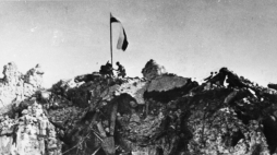 Po trzygodzinnej, zwycięskiej walce, patrol z 12. Pułku Ułanów Podolskich zatyka polską flagę nad rumowiskiem klasztoru Monte Cassino. 18.05.1944. Fot.  PAP/CAF