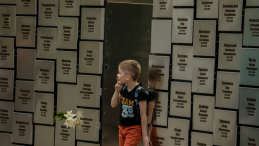 Chłopiec zwiedzający memoriał upamiętniający ponad 500 poległych i zidentyfikowanych ofiar rosyjskiej zbrodni w Buczy. Sierpień 2022 r. EPA/O. Petrasyuk