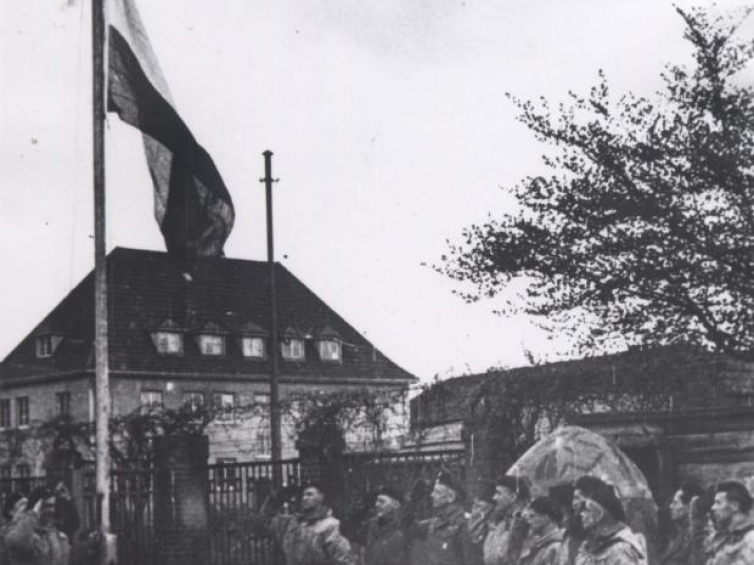 Wciąganie polskiej flagi na maszt w zajętym Wilhelmshaven, 5 maja 1945. Zbiory  Muzeum Wojska Polskiego