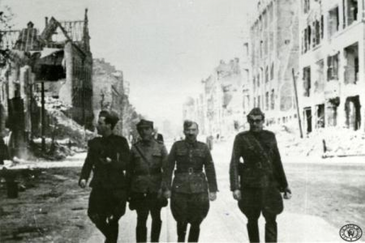 Oficerowie Wojska Polskiego idą ulicą w zrujnowanym Berlinie. Maj 1945 r. Źródło: CAW