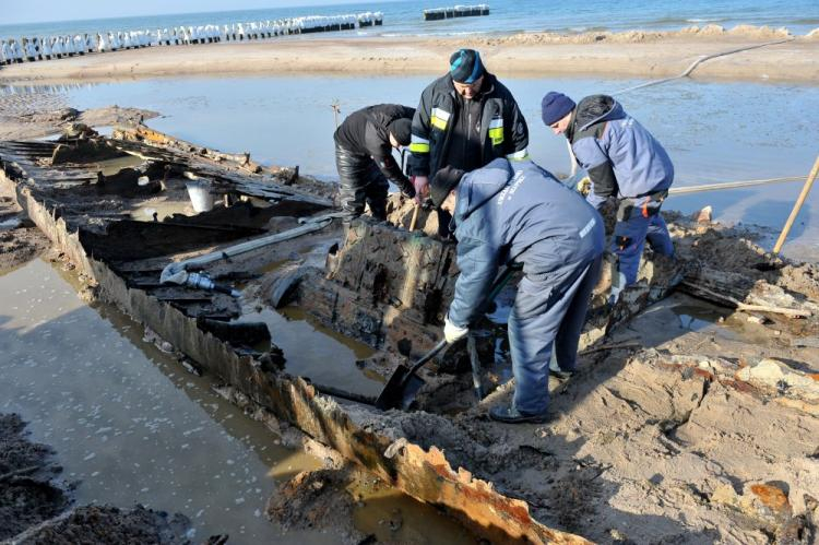 Operacja wydobycia elementów wraku odsłoniętego przez morze na plaży w Podczelu koło Kołobrzegu. Fot. PAP/M. Bielecki