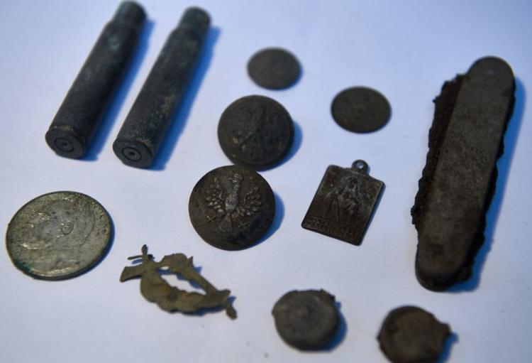 Przedmioty wykopane podczas prac archeologicznych na terenie Wojskowej Składnicy Tranzytowej Westerplatte w Gdańsku - guziki od mundurów polskich żołnierzy, szkaplerzyk, scyzoryk, łuski po nabojach z karabinu żołnierzy broniących Westerplatte, pięciozłotowa moneta z wizerunkiem Piłsudskiego. 24.08.2017. Fot. PAP/A. Warżawa