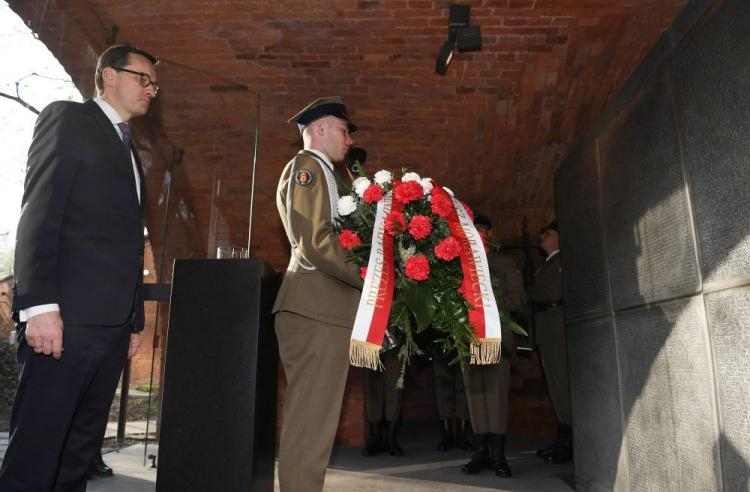 Premier Mateusz Morawiecki złożył kwiaty i zapalił znicze pod tablicami w Epitafium Katyńskim. Fot. PAP/R. Pietruszka