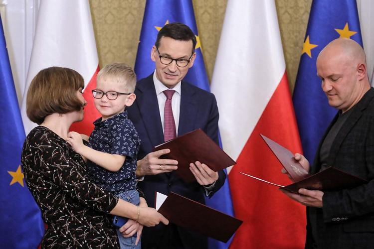 Premier Mateusz Morawiecki (C) wręcza akty nadania obywatelstwa polskiego repatriantom podczas spotkania w Domu Polonii w Pułtusku. Fot. PAP/P. Supernak