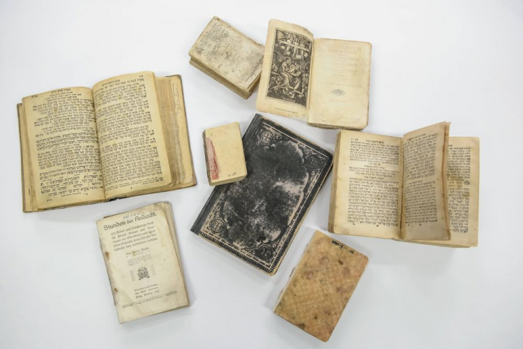 Siedem modlitewników i jeden kalendarzyk, z osobistymi zapiskami w języku francuskim, zaprezentowane po konserwacji w Państwowym Muzeum na Majdanku w Lublinie. 2017 r. Fot. PAP/W. Pacewicz