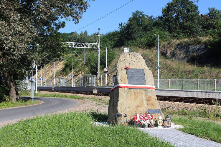Skalny monument upamiętniający ofiary katastrofy (w tle przystanek kolejowy i mijanka Barwałd Średni). Źródło: Wikimedia Commons