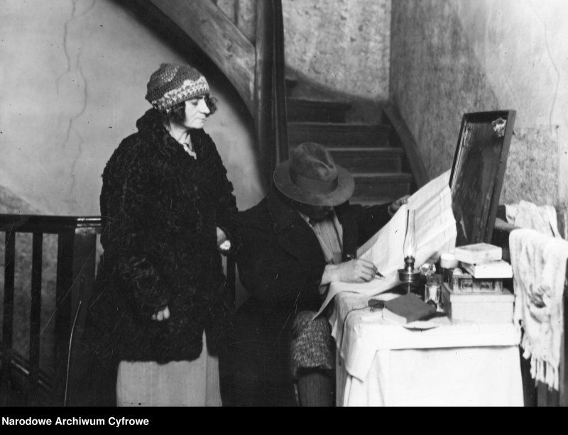 Bezdomna kobieta mieszkająca na klatce schodowej z pomocą komisarza spisowego wypełnia arkusz spisowy, Warszawa, 1931 r. Fot. Narodowe Archiwum Cyfrowe