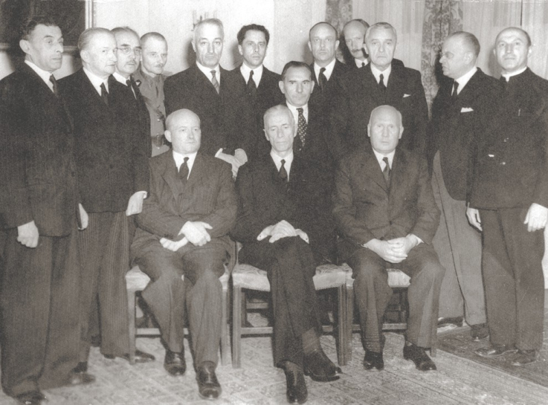 Rząd Stanisława Mikołajczyka (14 lipca - 29 listopada 1944). Siedzą od lewej Stanisław Mikołajczyk, Władysław Raczkiewicz i Jan Kwapiński. Stoją od lewej: Ludwik Grosfeld, Henryk Strasburger, Stanisław Kot, Marian Kukiel, Karol Popiel, Tadeusz Romer, Jan Stańczyk, Władysław Banaczyk, Adam Romer, Marian Seyda, Wacław Komarnicki, Zygmunt Kaczyński. Fot. https://upload.wikimedia.org/wikipedia/commons/e/e1/Rz%C4%85d_Miko%C5%82ajczyka_1944.jpg