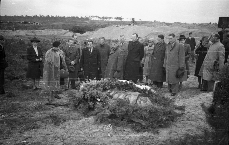 18 kwietnia 1946 r. Grób Mieczysława Niedziałkowskiego, redaktora naczelnego dziennika Polskiej Partii Socjalistycznej "Robotnik", zamordowanego w czerwcu 1940 w Palmirach, gdzie hitlerowcy dokonywali masowych egzekucji Polaków i Żydów. Przy grobie m.in. wdowa po zamordowanym Maria Niedziałkowska (druga do lewej) i prezydent Warszawy Stanisław Tołwiński (szósty od lewej). Fot. PAP/Bogusław Lambach 