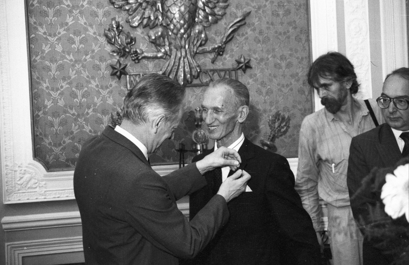1991 r. Rektor Uniwersytetu Warszawskiego (UW), Andrzej Kajetan Wróblewski przypina uniwersytecką odznakę Janowi Karskiemu. Fot. PAP/Ireneusz Radkiewicz