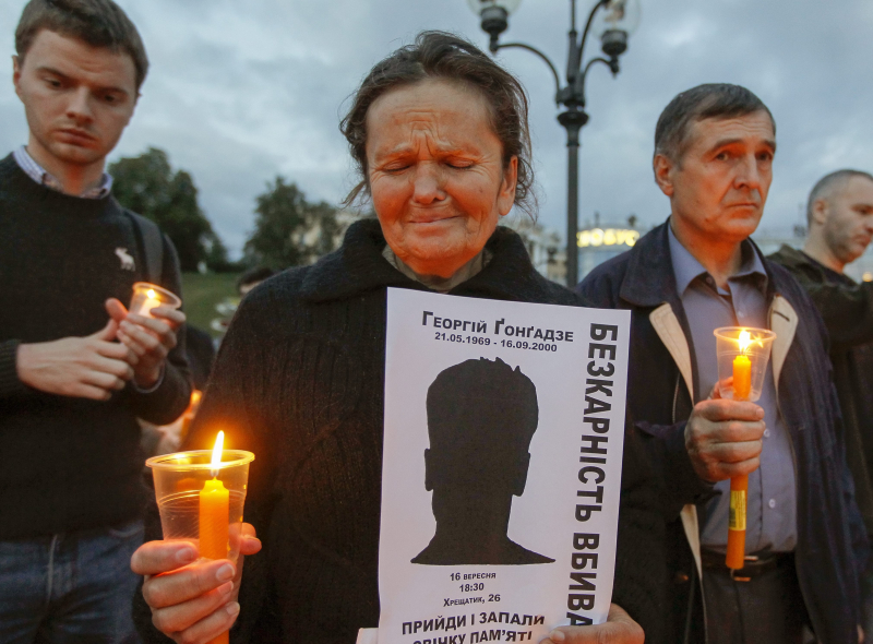 Ukrainka płacze, trzymając świecę i transparent z sylwetką Gieorgija Gongadze w centrum Kijowa na Ukrainie, 16 września 2013 r., podczas wiecu poświęconego pamięci wszystkich poległych ukraińskich dziennikarzy w rocznicę śmierci Gongadze w 2000 r. Fot. EPA/SERGEY DOLZHENKO Strona: PAP/EPA