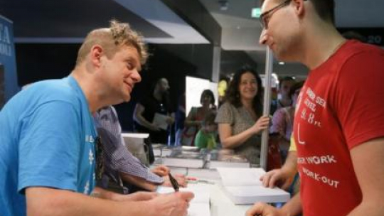 Kazik Staszewski podpisuje swoją książkę "Tato mimo woli". V Warszawskie Targi Książki. Fot. PAP/P. Supernak