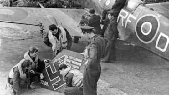  Lotnicy dywizjonu 303 oglądają szczątki zestrzelonego niemieckiego junkersa. Z prawej „Spitfire” Jana Zumbacha Fot. NAC