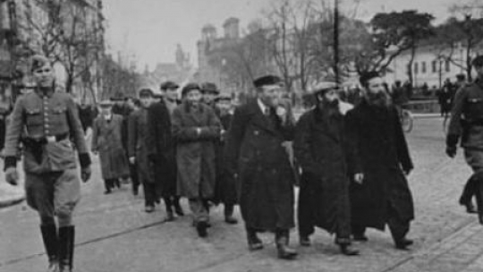 Żydzi eskortowani w drodze do pracy na Krakowskim Przedmieściu. Marzec 1940 r. Źródło: IPN