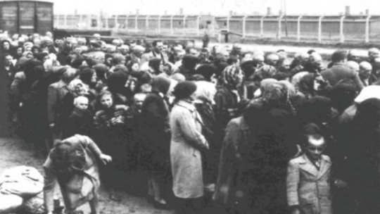 Żydowskie kobiety i dzieci oczekujące na selekcję na rampie w Birkenau. 1944 r. Fot. Państwowe Muzeum Auschwitz-Birkenau