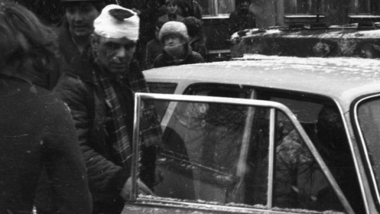Pacyfikacja KWK Wujek - przy karetce pogotowia górnik ranny podczas szturmu ZOMO na kopalnię. Katowice 16.12.1981. Fot. PAP/M. Janicki