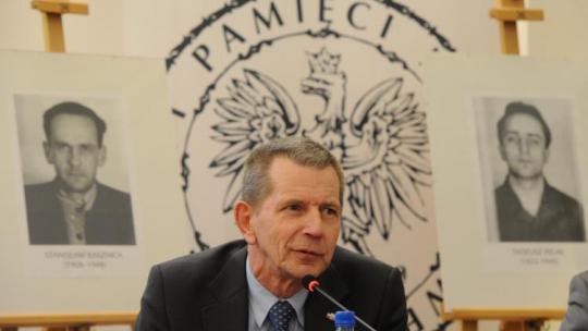 Andrzej Kunert, Sekretarz Rady Ochrony Pamięci Walk i Męczeństwa, podczas konferencji prasowej poświęconej wynikom identyfikacji ofiar komunistycznej bezpieki, które udało się zidentyfikować po ekshumacjach na warszawskich Powązkach. W tle portrety Stanisława Kasznicy (L) i Tadeusza Pelaka (P), ofiar terroru komunistycznego. Fot. PAP/G. Jakubowski.  