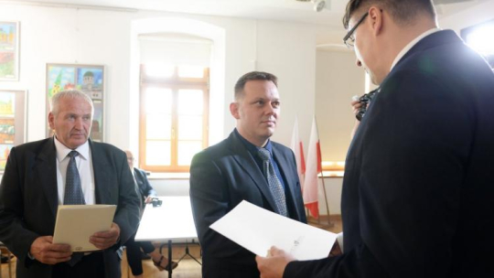 Przedstawiciele rodzin zamordowanych żołnierzy antykomunistycznego podziemia Jan Pecel (L) oraz Marcin Popiel (C) odbierają noty identyfikacyjne z rąk prezesa Fundacji Niezłomni Wojciecha Łuczaka (P). Fot. PAP/P. Polak