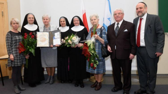 Naczelny rabin Polski Michael Schudrich (P), Jan Budnowski (2P), Krystyna Kabat (3P) i ich bliscy z medalem dla Tekli Budnowskiej. Fot. PAP/J. Kaczmarczyk