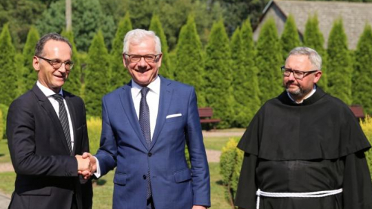 Harmęże (woj. małopolskie), 20.08.2018. Ministrowie spraw zagranicznych, Polski Jacek Czaputowicz (C), Niemiec Heiko Maas (L) i gwardian o. Piotr Cuber (P) podczas powitania przed spotkaniem przy wejściu do Centrum św. Maksymiliana w miejscowości Harmęże koło Oświęcimia. Fot. PAP/A. Grygiel