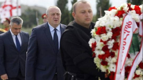 Gruziński prezydent Giorgi Margvelashvili (C) uczestniczy w uroczystości składania wieńców na cmentarzu w Tbilisi. Oficjalna ceremonia odbyła się tutaj z okazji dziesiątej rocznicy konfliktu rosyjsko-południowoosetyjsko-gruzińskiego. Fot. PAP/EPA
