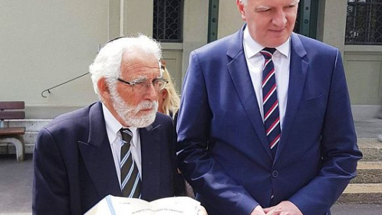 Uri Strauss, jeden z Ocalonych przez konsula Konstantego Rokickiego, pokazuje wicepremierowi Jarosławowi Gowinowi paszport, który uratował mu życie. Uroczystości w 120. rocznicę urodzin Konstantego Rokickiego w Szwajcarii. Fot. Ministerstwo Nauki i Szkolnictwa Wyższego