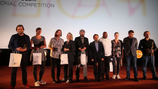 Reżyserzy Andrzej Cichocki (L), Michalina Musialik (2L), Nastazja Gonera (4L), Tomasz Wolski (5L), Krzysztof Czyżewski (5P), Jan P. Matuszyński (2P) i Tomasz Wysokiński, aktor Daniel Namiotko (3L), krytyczka filmowa Adriana Prodeus (3P) i bohater filmu „Spacer z Aniołami” Jeremaiah Marobyane (4P) podczas ceremonii wręczenia nagród 61. Krakowskiego Festiwalu Filmowego. Fot. PAP/Ł. Gągulski