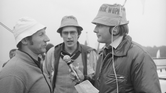 Mikołajki 08.1980. Realizacja cyklicznej audycji pt. Lato z Radiem. Na zdjęciu: statek ratowniczy Koncha, redaktorzy Wojciech Reszczyński (C) i Mieczysław Marciniak (P) rozmawiają z polskim żeglarzem, olimpijczykiem z XX Letnich Igrzysk Olimpijskich w Monachium w 1972 roku, Zbigniewem Kanią (L). Fot. PAP/M. Belina Brzozowski