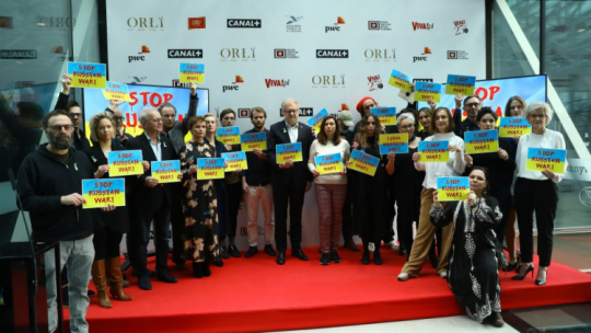 Warszawa, 16.03.2022. Prezydent Polskiej Akademii Filmowej Dariusz Jabłoński (C-L) i Ukrainka Julia Sinkiewicz (C-P) i twórcy filmowi podczas ogłoszenia nominacji do nagród filmowych Orły 2022, w Fabryce Norblina w Warszawie. Fot. PAP/R. Guz