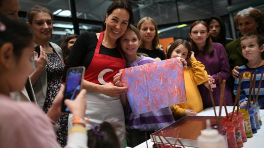 Nadarzyn, 19.05.2022. Mistrzyni ebru, a także kaligrafii i miniatury Suna Kocal (C-L) podczas warsztatów tradycyjnej tureckiej sztuki zdobienia papieru ebru dla uchodźców z Ukrainy w Centrum Pomocy Humanitarnej Ptak w Nadarzynie, 19 bm. Wydarzenie zorganizowała ambasada Turcji w Polsce. Fot. PAP/M. Obara