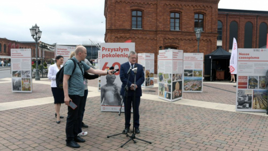 Wicepremier, minister kultury i dziedzictwa narodowego Piotr Gliński (P) podczas otwarcia wystawy plenerowej „Przyszłym pokoleniom. 60 lat misji Narodowego Instytutu Dziedzictwa” na Rynku Manufaktury w Łodzi. Fot. PAP/G. Michałowski