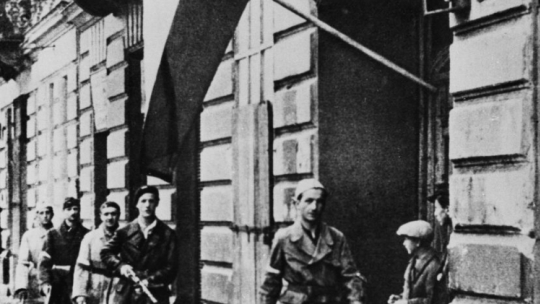 Pierwszy dzień Powstania Warszawskiego: patrol porucznika Stanisława Jankowskiego ps. Agaton (idzie pierwszy) z batalionu Pięść na pl. Kazimierza Wielkiego w drodze do Śródmieścia. Fot. PAP/Reprodukcja