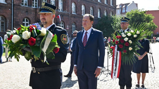  Gdańsk, 09.08.2022. Ambasador USA w Polsce Mark Brzezinski (C) podczas uroczystości złożenia kwiatów przy pomniku Obrońców Poczty Polskiej w Gdańsku. Fot. PAP/M. Gadomski 