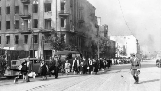 Warszawa. Ludność cywilna Woli prowadzona przez Niemców ulicą Wolską, przypuszczalnie w pierwszych dniach sierpnia 1944 r. podczas tzw. Rzezi Woli. Fot. Bundesarchiv. Źródło: Wikimedia Commons