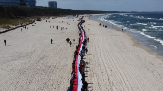 Międzyzdroje, 02.05.2023. Najdłuższa flaga w Polsce. Na plażę została wniesiona w dwóch częściach. Fot. PAP/M. Bielecki