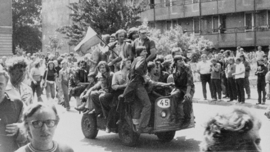 Radom, 1976-06-25. Grupa młodych ludzi jadących akumulatorowym wózkiem z narodową flagą pod gmach Komitetu Wojewódzkiego Polskiej Zjednoczonej Partii Robotniczej (KW PZPR). Fot. PAP/CAF