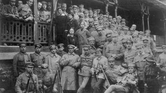 Oddziały Strzelców w "Oleandrach" w Krakowie. Pośrodku widoczna kobieta z szablą i rewolwerem w kaburze, z prawej chłopiec w mundurku skautowskim. Widoczne również karabiny Mannlicher wz. 1890 ustawione w kozły. 08.1914. Fot. NAC