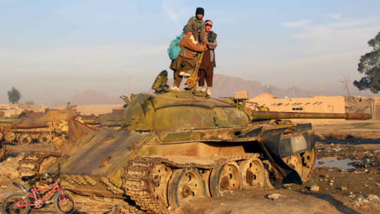 Afgańskie dzieci na wraku radzieckiego czołgu, zniszczonego w trakcie inwazji Związku Radzieckiego, fot. PAP/EPA/Sadiq