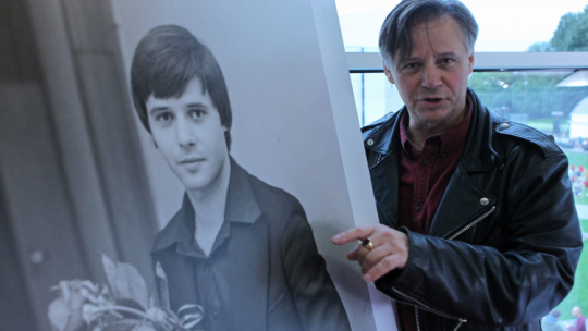 Krzysztof Janczar w 2015 r. ze swoim zdjęciem z lat młodości, fot. PAP/P. Wittman