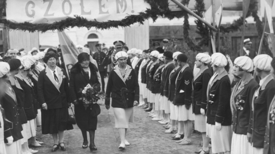 Michalina Mościcka (trzyma bukiet kwiatów) w towarzystwie dwóch kobiet przechodzi przed szpalerem wioślarek, lata 1927-1930. /NAC