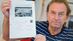 Guenter Zetti prezentuje kopię wysłanej pocztówki z akt Stasi. Fot. PAP/EPA