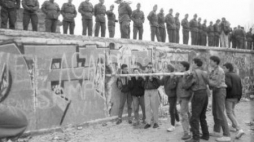 Burzenie muru berlińskiego od strony Berlina Zach. Na murze funkcjonariusze straży granicznej NRD. Fot. PAP/J. Undro