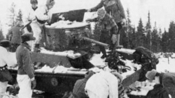 Fińscy żołnierze przy porzuconym podczas Wojny Zimowej sowieckim czołgu T-26. Styczeń 1940 r. Fot. Wikimedia Commons