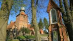 Zabytkowy kościół parafialny z XV wieku i warmińska kapliczka w Sząbruku. Fot. PAP/T. Waszczuk