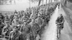 Kolumna niemieckich wojsk eskortowana przez polskich żołnierzy opuszcza Berlin po kapitulacji. Fot. PAP/CAF/Polpress