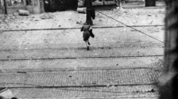  Jerzy Tomaszewski - Łączniczka przebiega pod ostrzałem przez ulicę Nowy Świat. Źródło: IPN